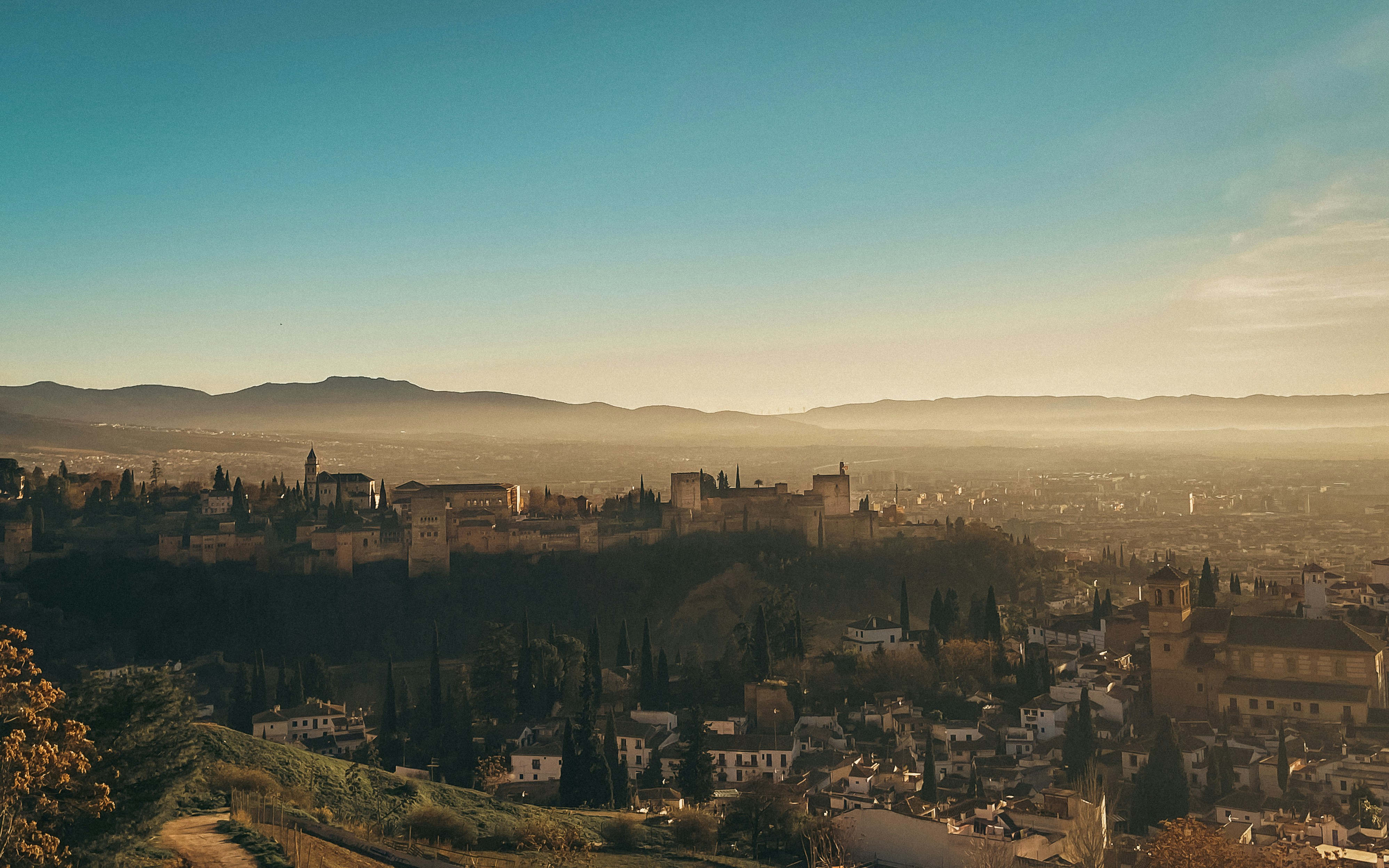 A panoramic view of Brașov city center with the Tampa Mountain in the background during sunset.