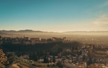 A panoramic view of the ancient castle walls overlooking the city of Jaén at sunset.