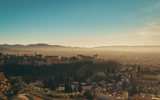 A panoramic view of Brașov city center with the Tampa Mountain in the background during sunset.