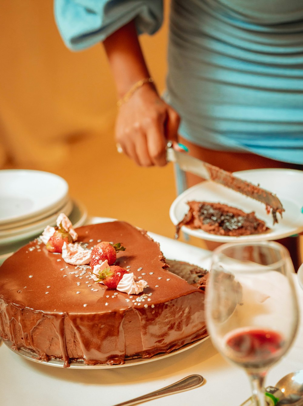 a person cutting a piece of cake on a table