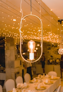 a long table with a light bulb hanging from the ceiling