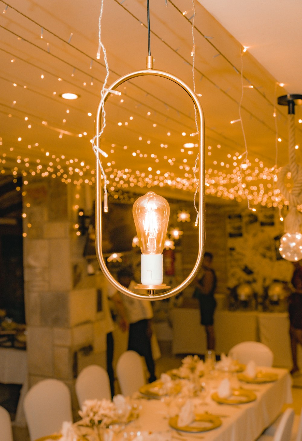 a long table with a light bulb hanging from the ceiling