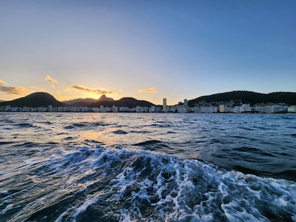 A beautiful sunset view of Rio de Janeiro's coastline with iconic landmarks in the background.