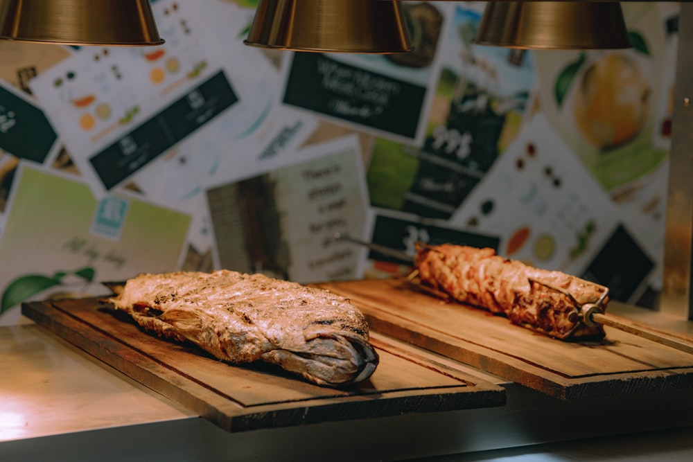 two steaks sitting on cutting boards on a counter