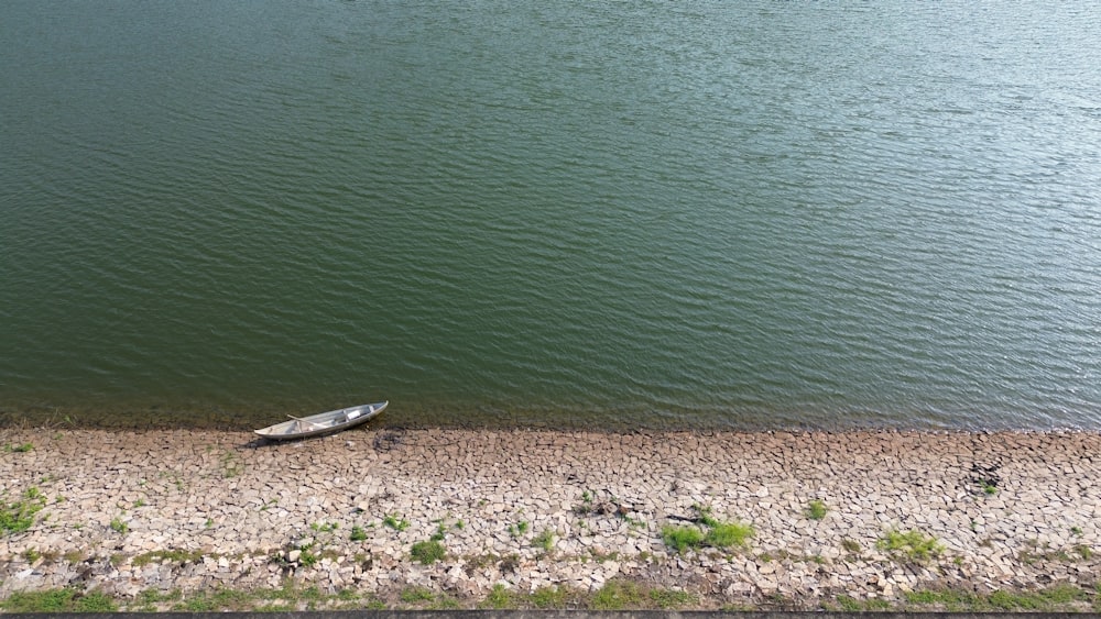 a small boat sitting on the shore of a lake