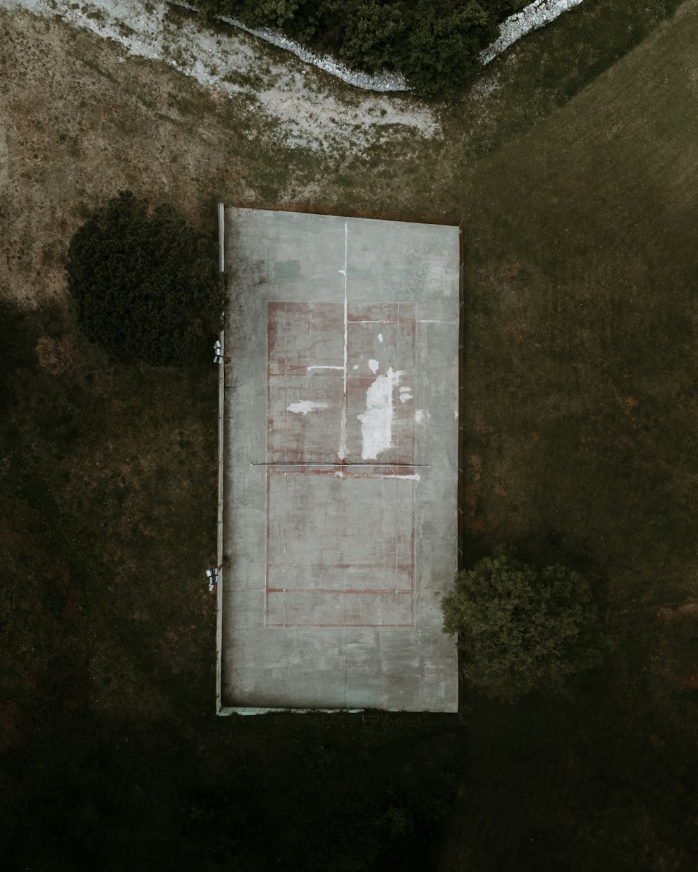 an aerial view of a tennis court in a field