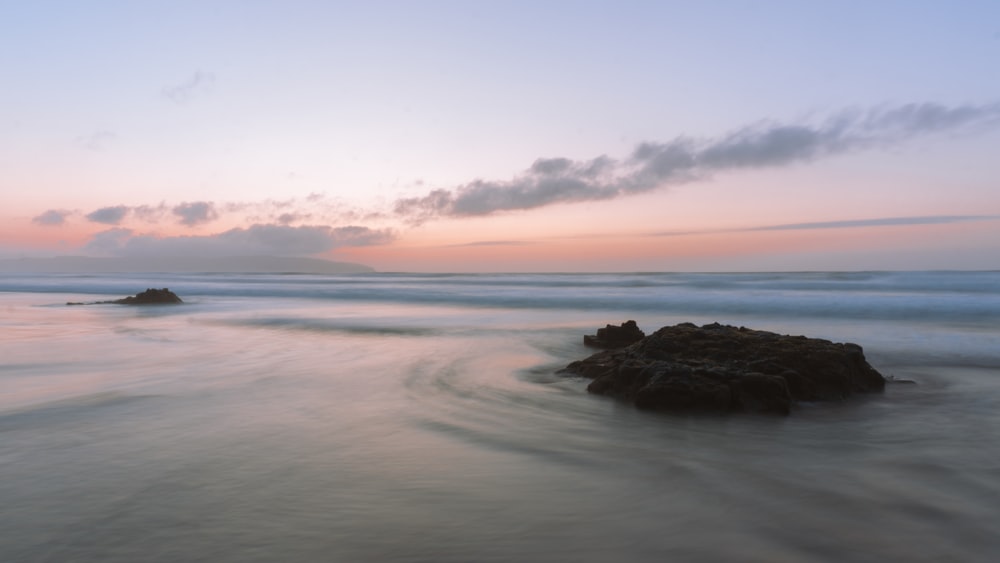 a long exposure photo of a beach at sunset