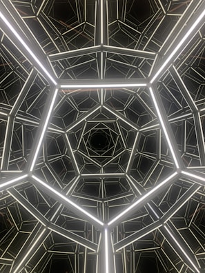 Geometric pattern featuring interconnected luminous lines forming pentagon shapes, creating a tunnel-like effect with depth and symmetry.