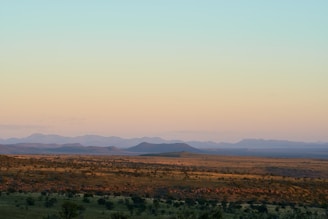 Wide open mountain landscape under a clear sky at sunset