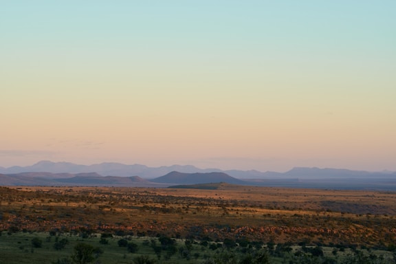 Wide open mountain landscape under a clear sky at sunset