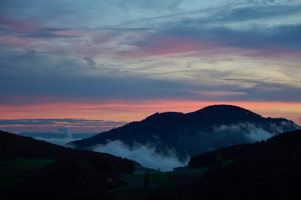 the sun is setting over a mountain range