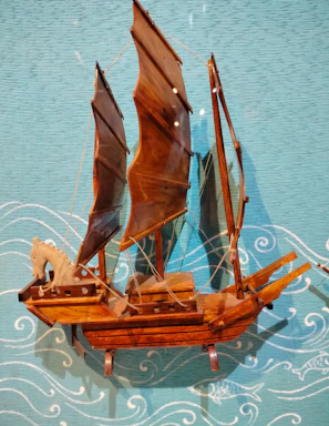 An old wooden ship model displayed with weathered ropes and maritime tools.