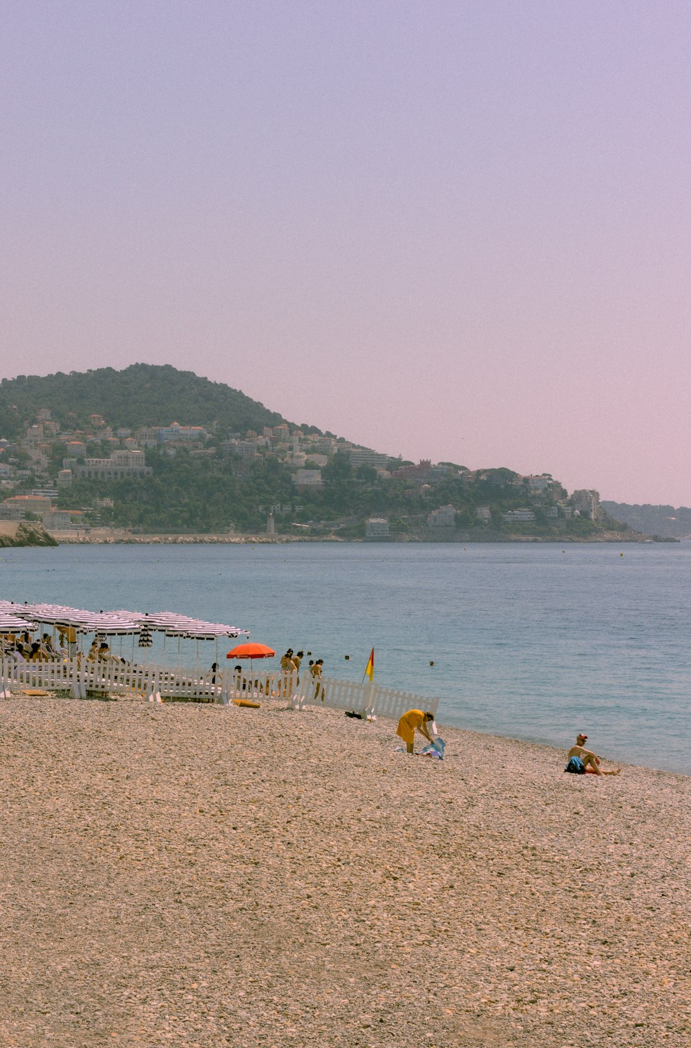 a group of people standing on top of a sandy beach