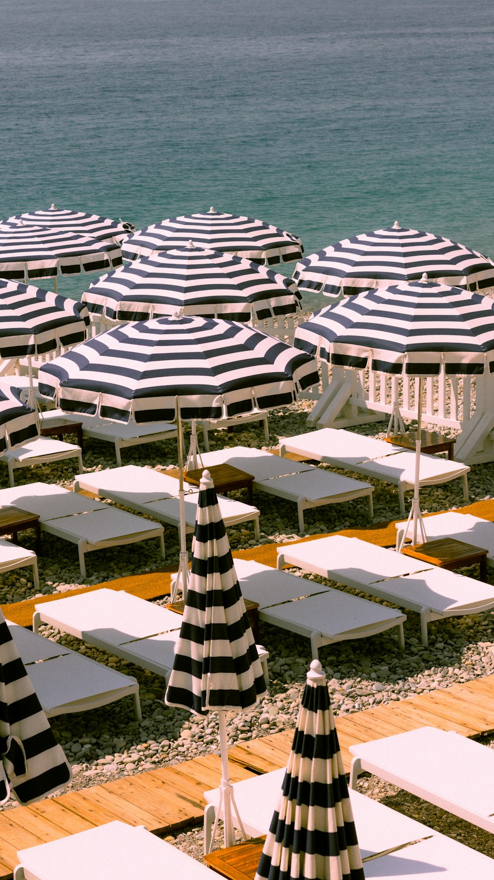 a bunch of lawn chairs and umbrellas on the beach