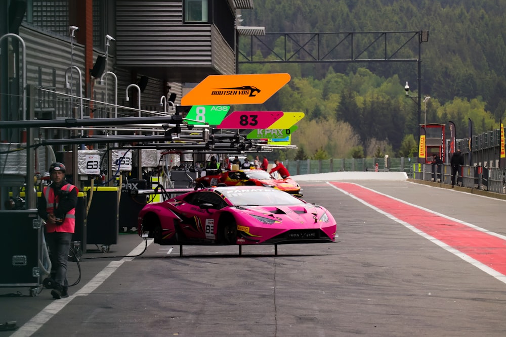 a pink race car driving down a race track