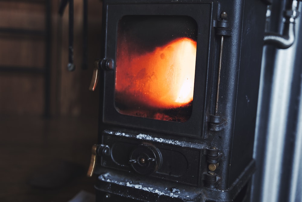 a black stove with an orange flame inside of it