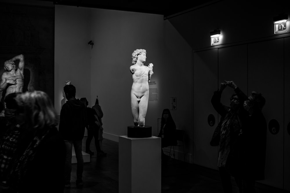 a black and white photo of a statue in a museum