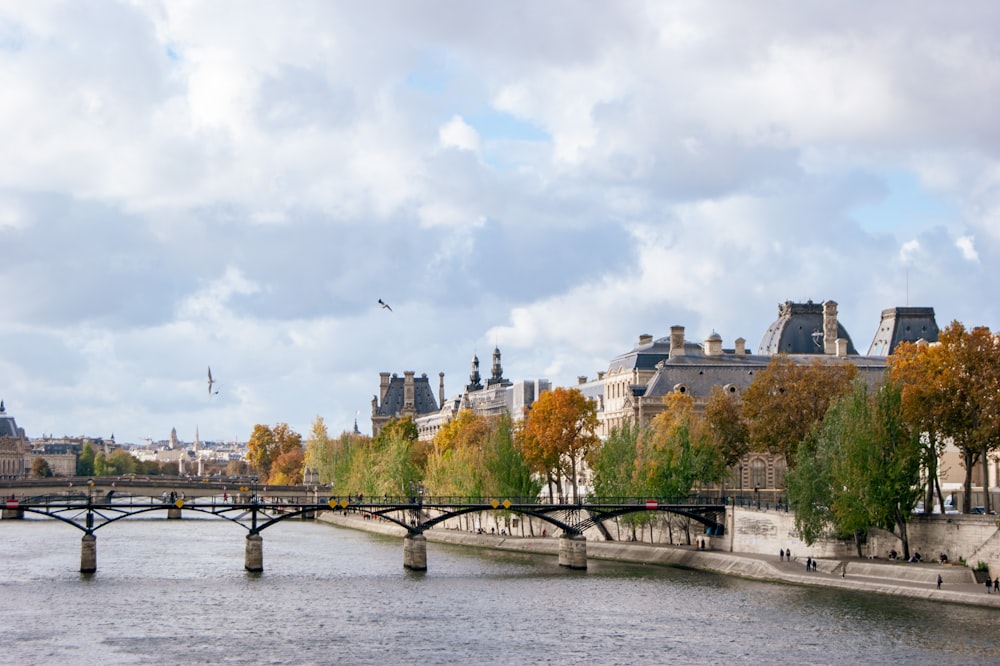 a bridge over a body of water with buildings in the background