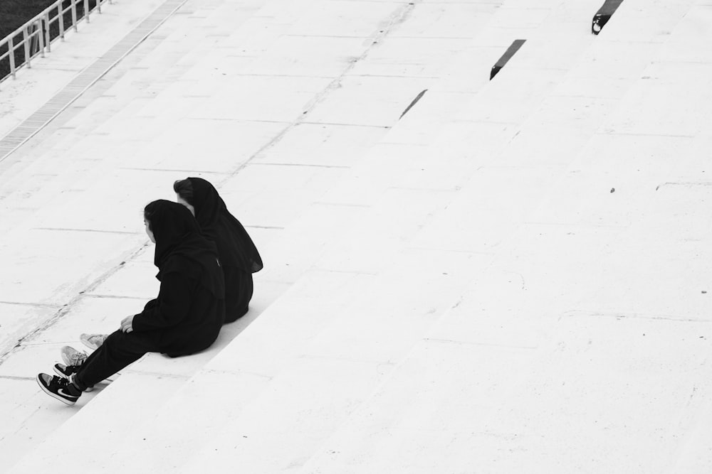 a person sitting on the ground in the snow