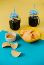 a bowl of chips next to a bowl of dip