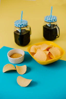 a bowl of chips next to a bowl of dip