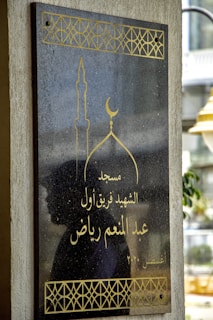 Close-up of a sleek black wooden plaque engraved with intricate geometric patterns glowing softly under moody lighting