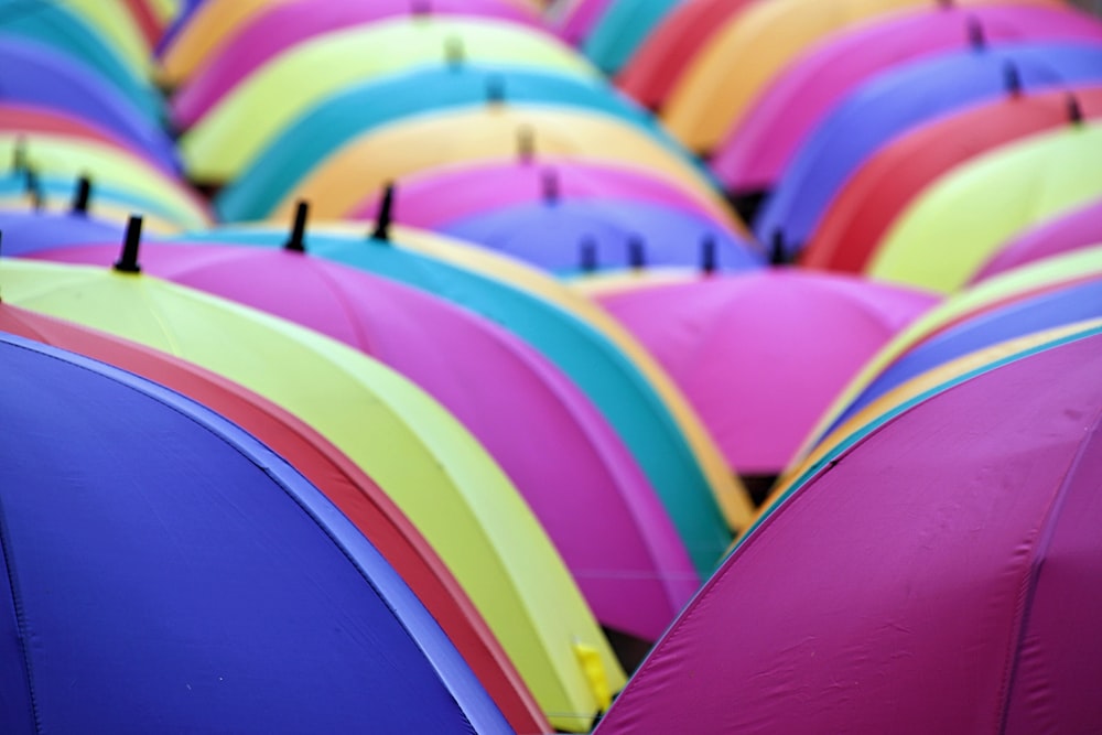 a large group of colorful umbrellas with pins sticking out of them