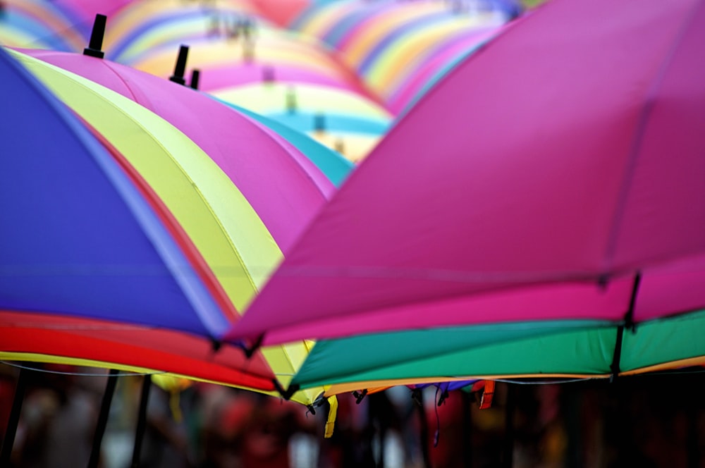 eine Gruppe bunter Regenschirme, die in einer Reihe hängen