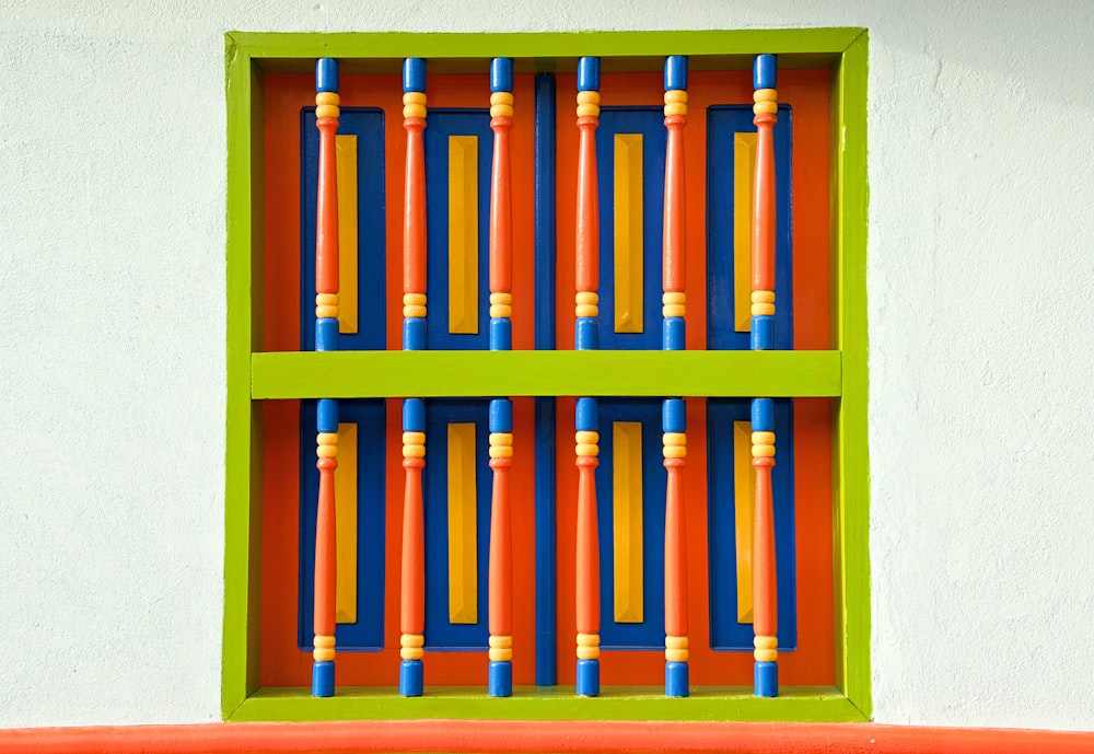 an orange and blue wall with a green window