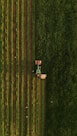 an aerial view of a tractor plowing a field