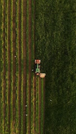 an aerial view of a tractor plowing a field