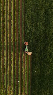 an aerial view of a tractor plowing a field