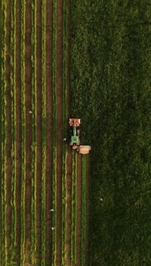 an aerial view of a tractor plowing a field