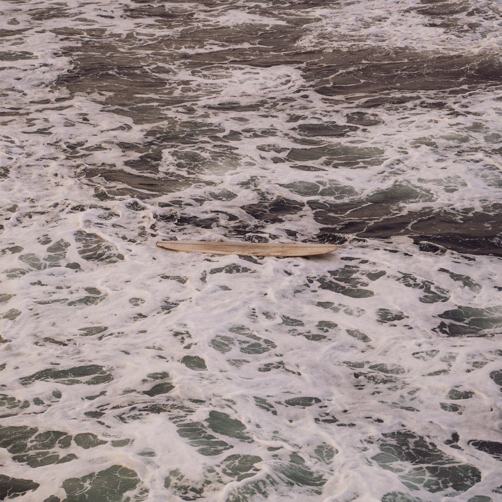 a surfboard laying on top of a body of water