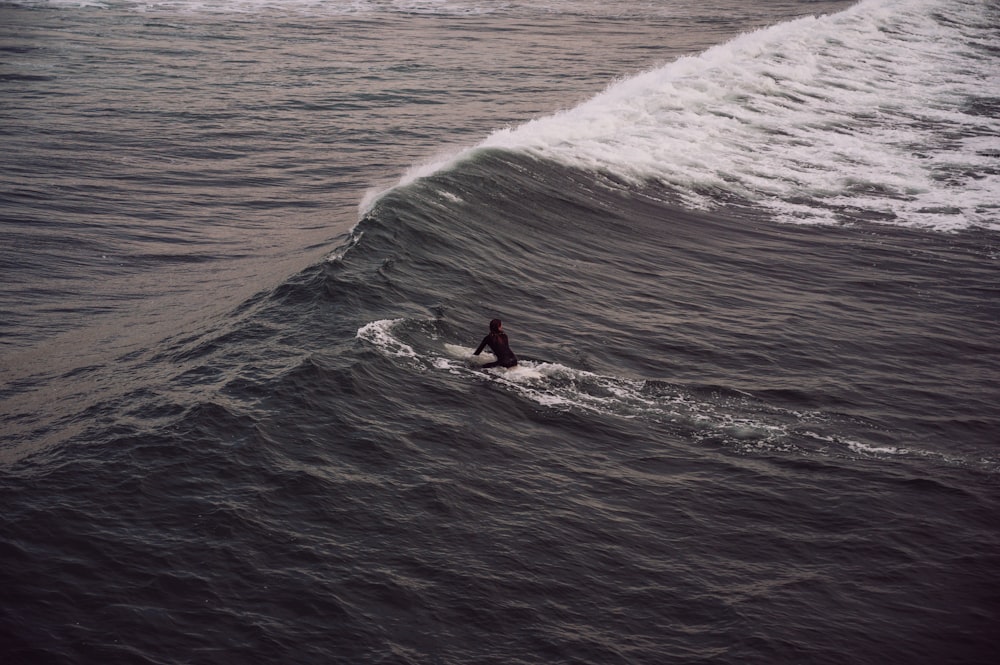 a man riding a wave on top of a surfboard