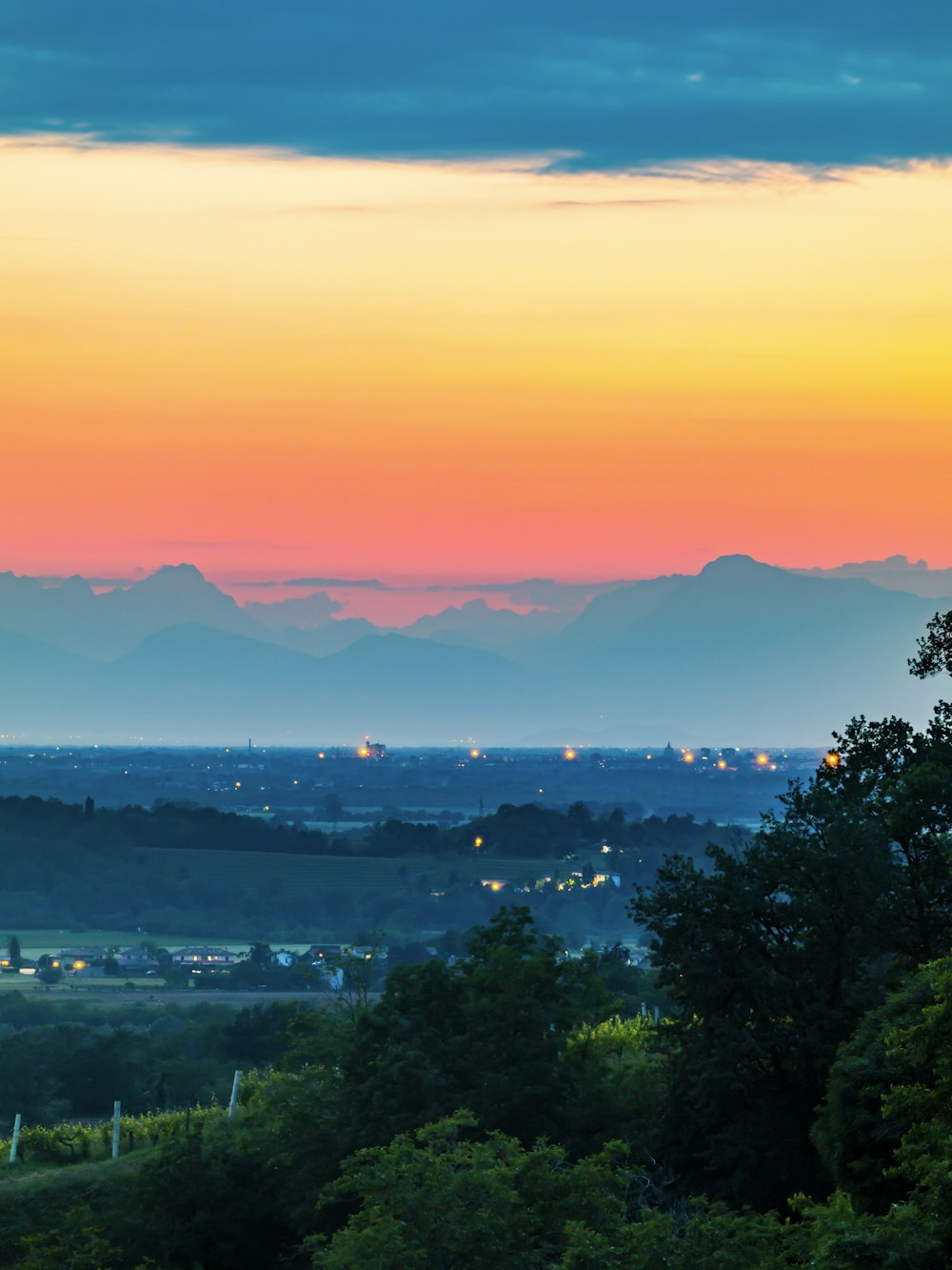 a view of a sunset over a valley with mountains in the distance