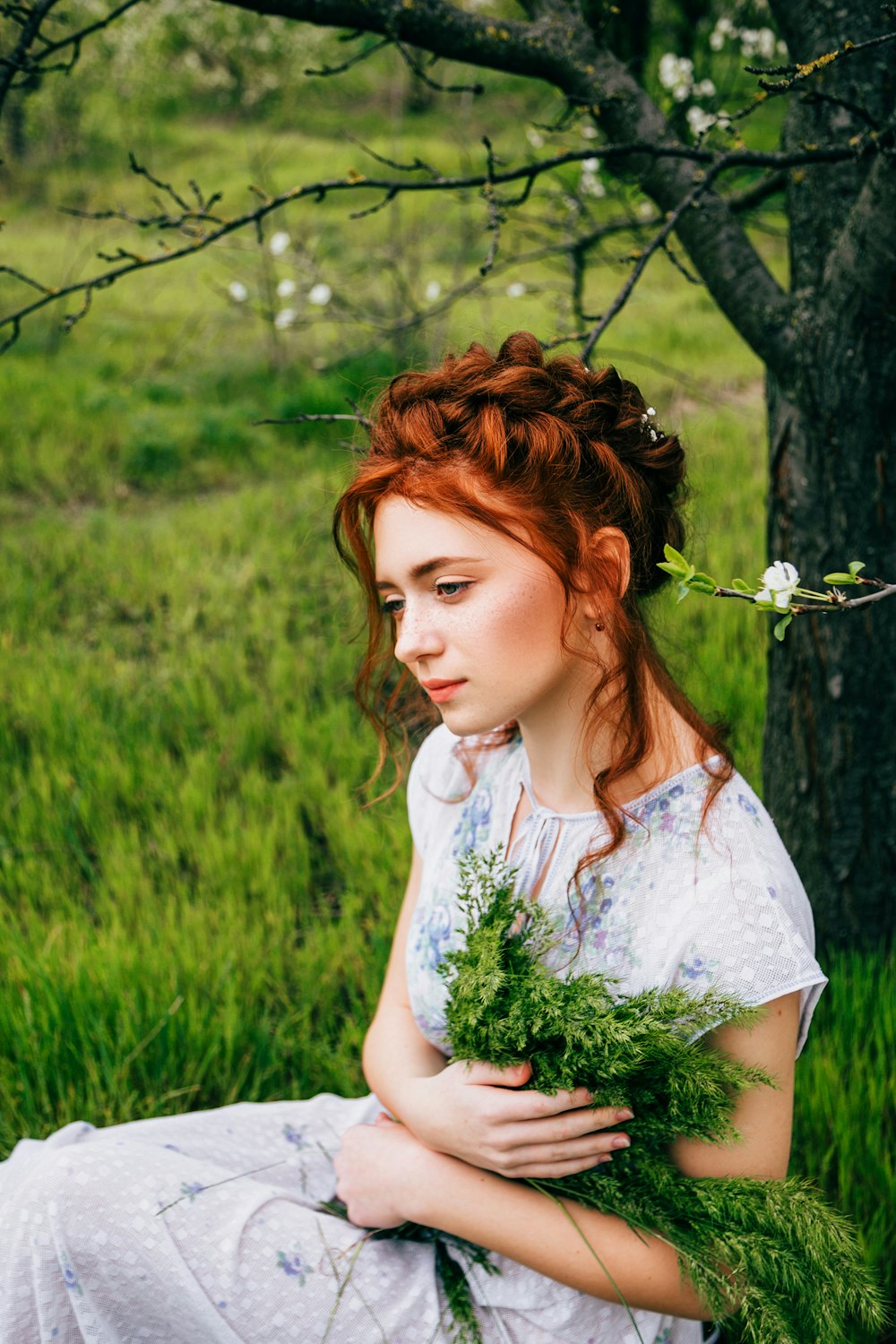 a woman in a white dress holding a bunch of flowers