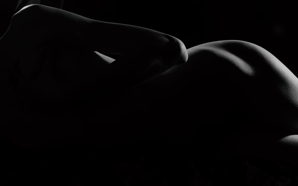 a naked woman laying down in the dark