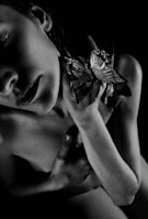 A powerful black-and-white image of a butterfly resting on a worn leather jacket, symbolizing transformation.