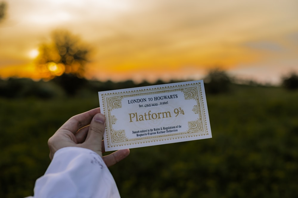 a person holding up a business card in a field