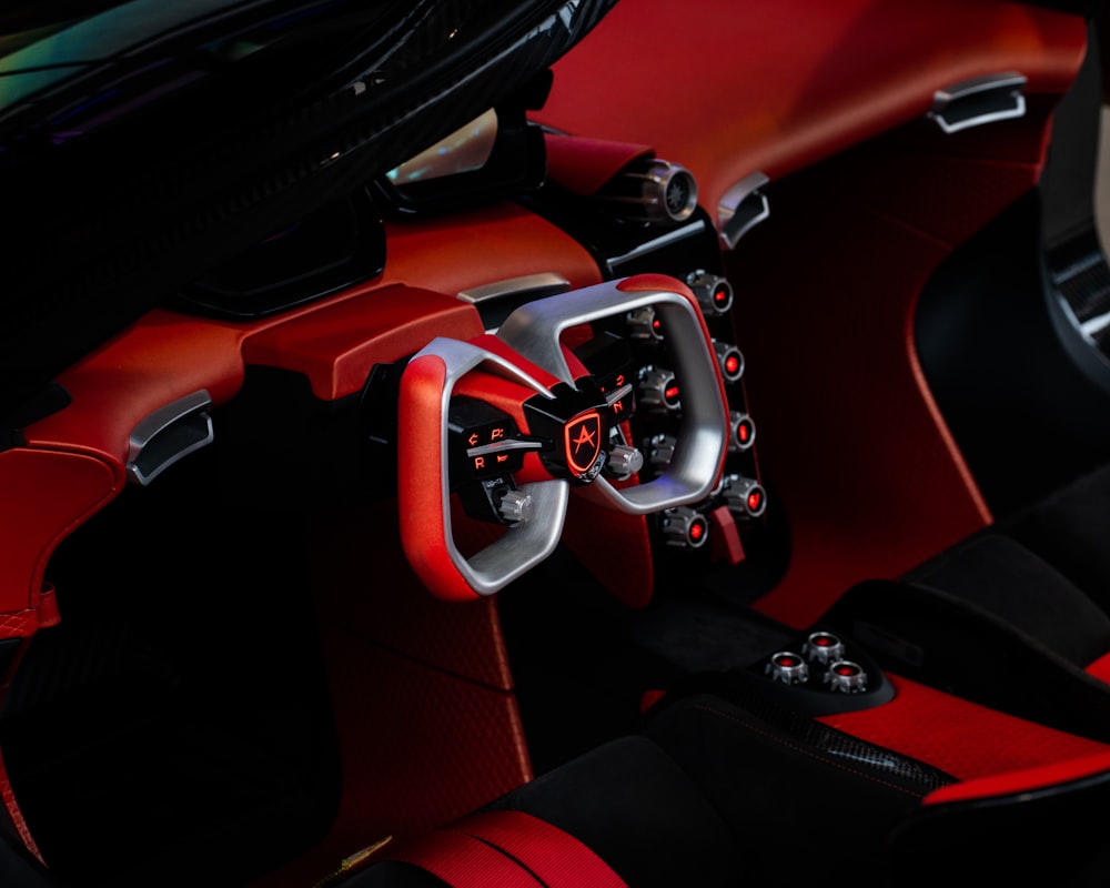 the interior of a sports car with red and black leather