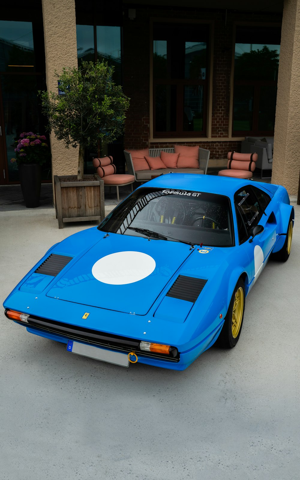 a blue sports car parked in front of a building