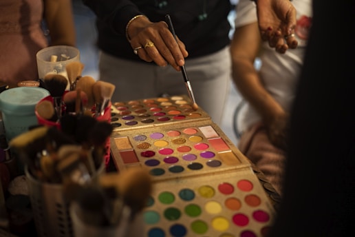 a group of people standing around a table with makeup