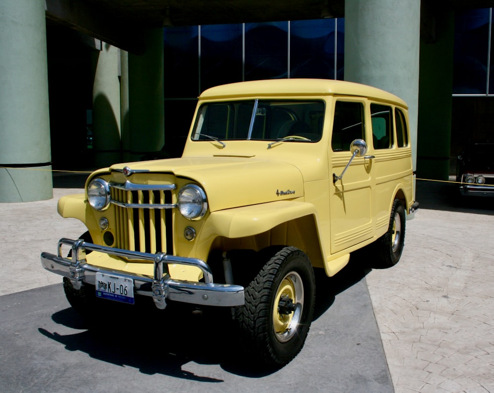 a yellow jeep parked in front of a building
