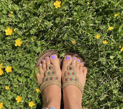 Feet with painted nails stepping gently on soft rose petals.