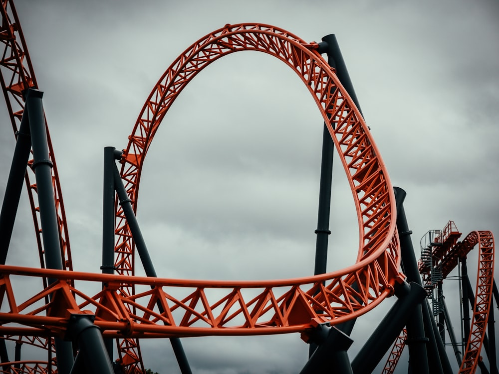 an orange roller coaster on a cloudy day