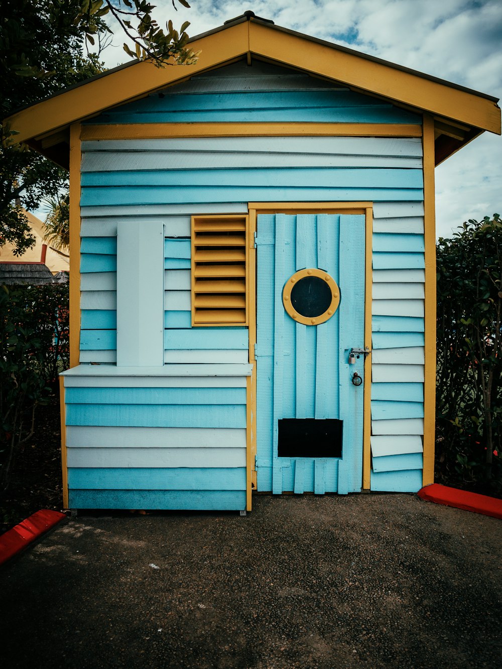 a blue and yellow building with a round window