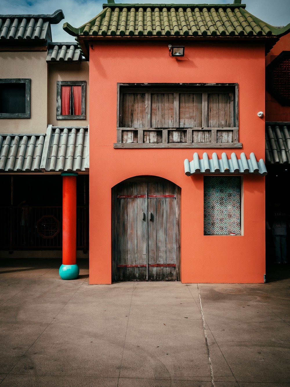 an orange building with a blue vase in front of it