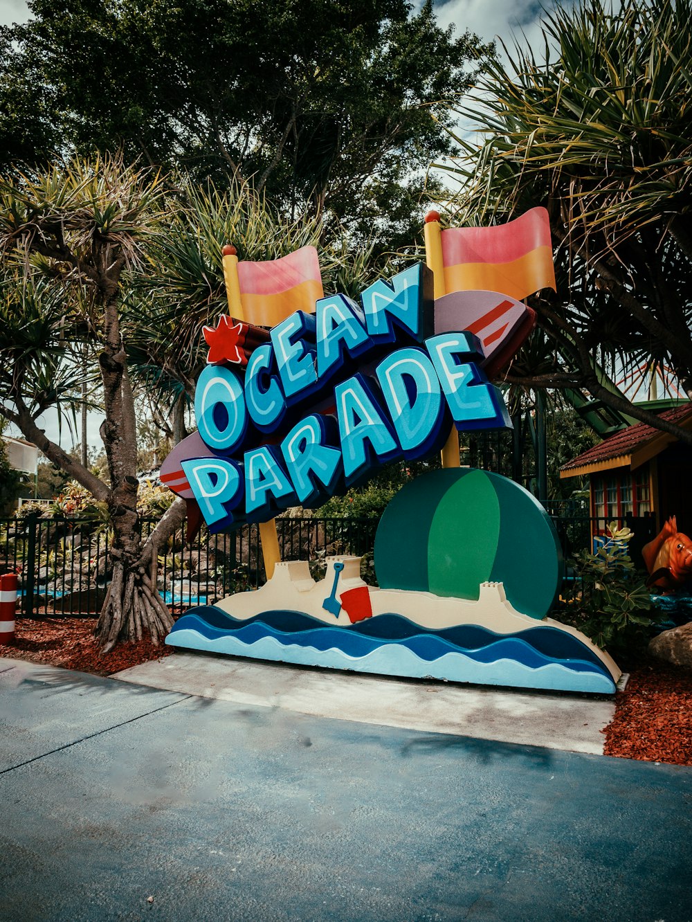 a sign that says ocean parade in front of a fence