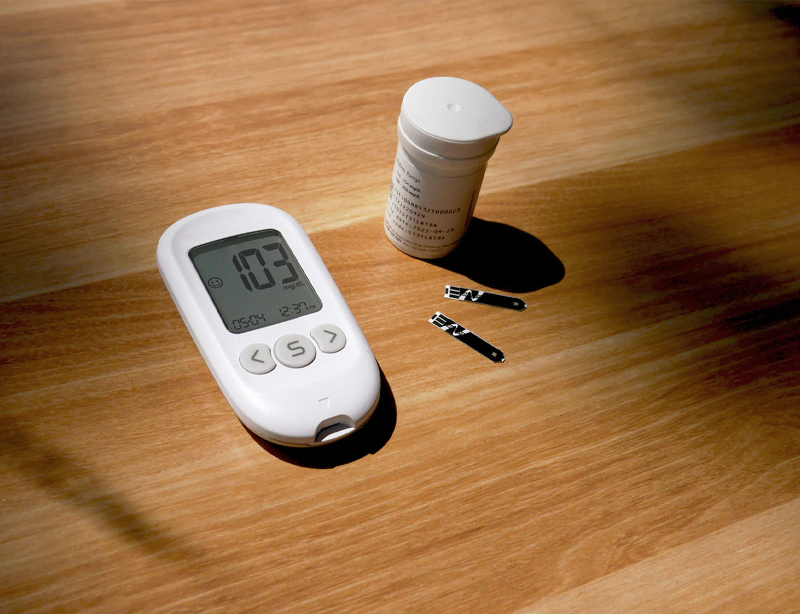 Thermometer, tablets and a medicine bottle laid out on a table